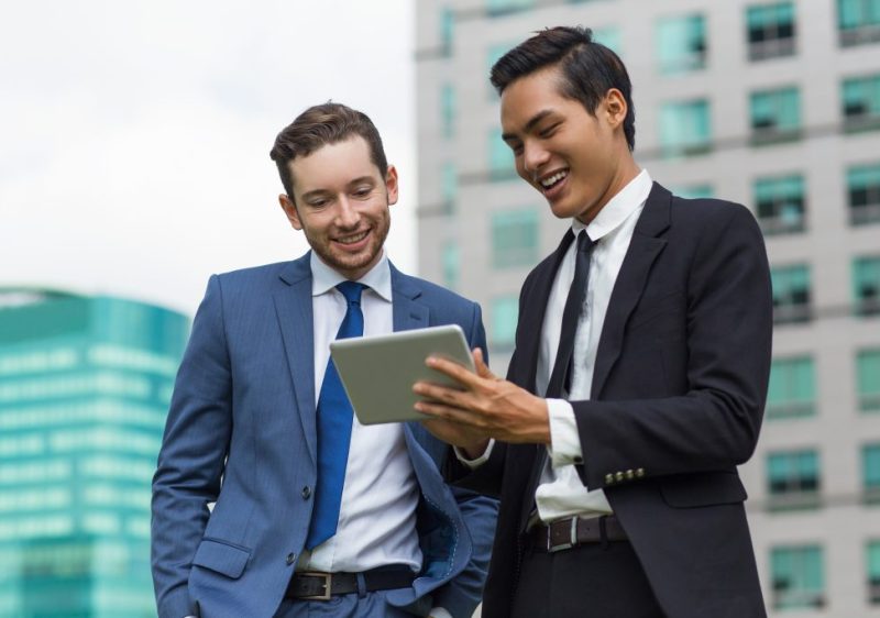 closeup-smiling-coworkers-using-tablet-outdoors-1024×683
